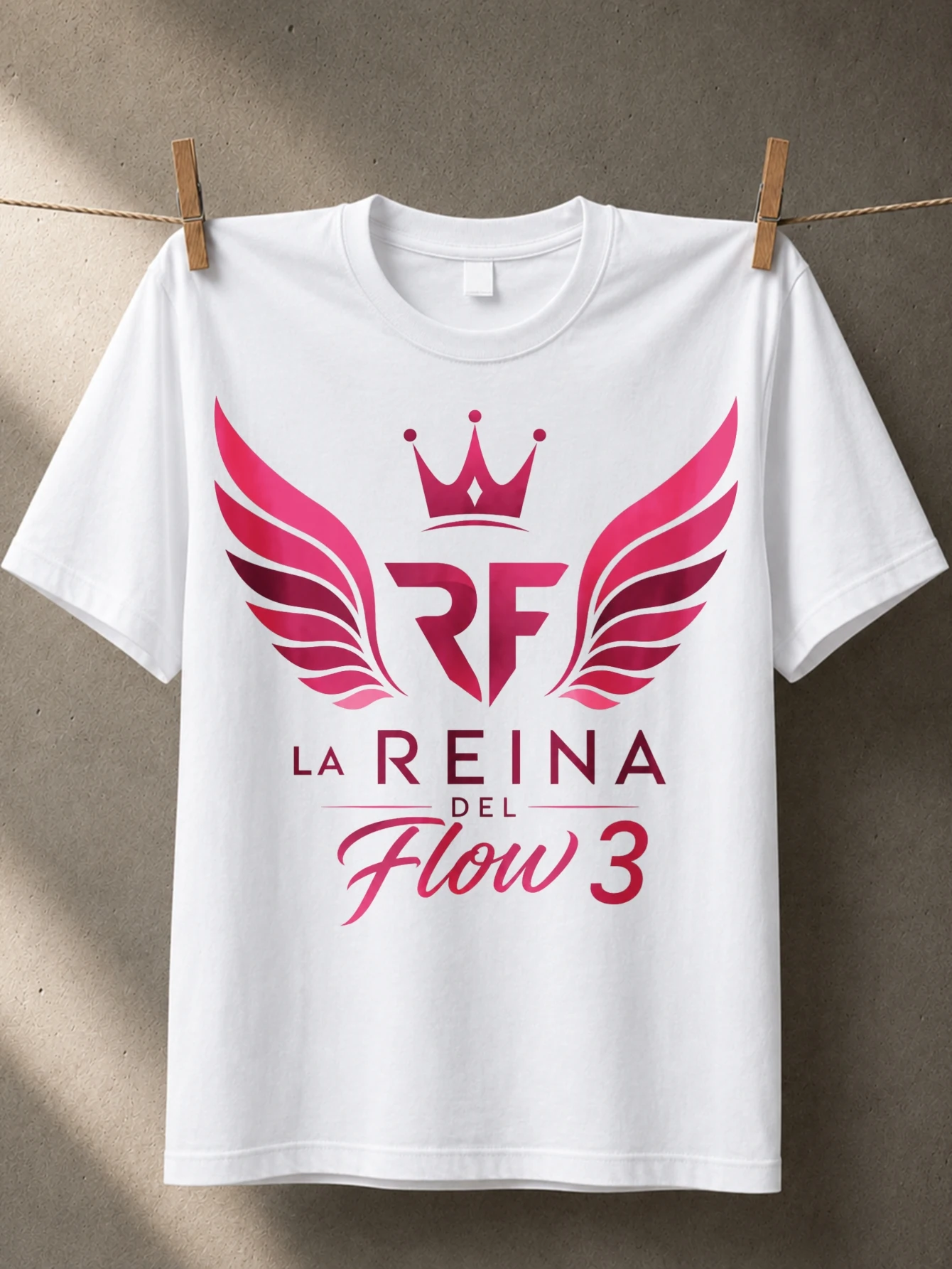 Camiseta unisex con el logo de la corona de alas rosas de L-a Re-ina del Fl-ow 3 y tipografía de flujo de la reina española en español.