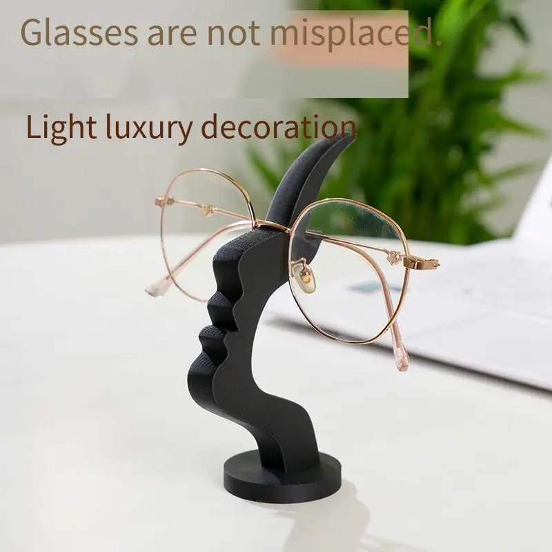 Sculpturalny stojak na okulary: elegancki kształt siluety twarzy zapewniający bezpieczeństwo okularów i stylowy, minimalistyczny profil twarzy jako podstawka pod okulary.