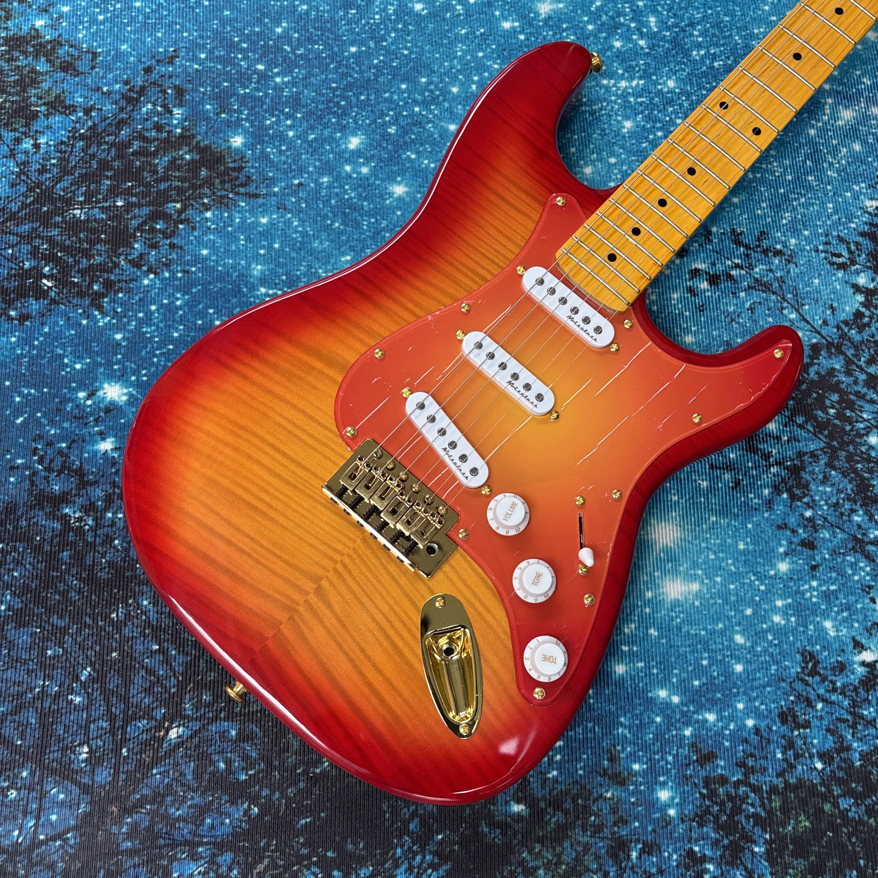 

Электрогитара с красно-оранжевым градиентным покрытием, электрогитары с золотой фурнитурой, электрогитара с звукоснимателями SSS.