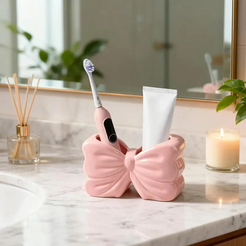 Cute Pink Bow Plastic Toothbrush Holder with 2 Slots Designed for Storing Bathroom and Makeup Brushes.