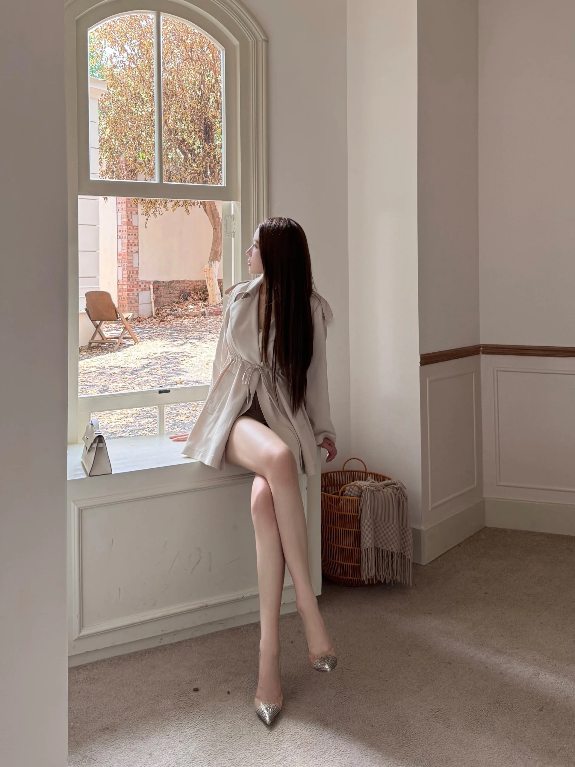 

Светло-бежевая демисезонная тонкая ветровка на шнуровке с гладкой талией, простая, свободного кроя, удлиненная, средней длины.