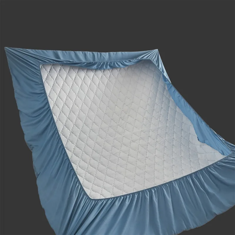A quilted bed skirt-style bed cover fully enclosing waterproof padded mattress protector with anti-slip design.