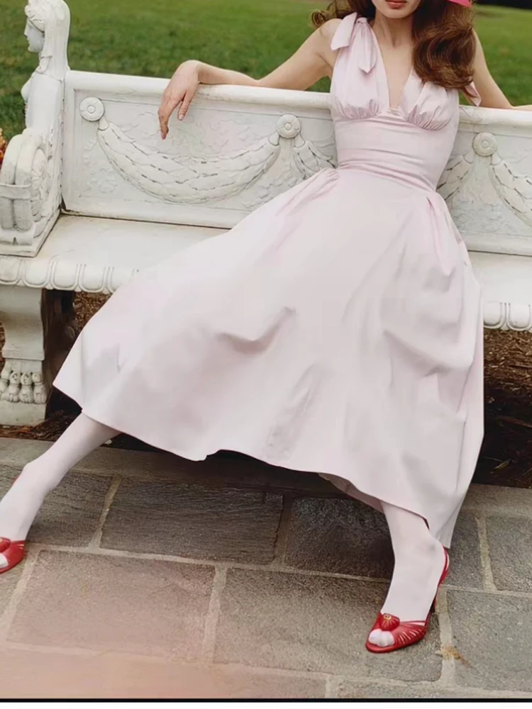Deep V-necked halter dress with wide sleeves, fitted at the waist, revealing the back, women's style, summer 2026 new collection