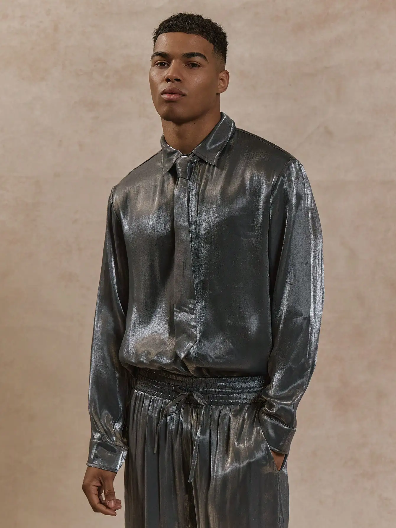 

Мужская рубашка с длинным рукавом, серебристого металлического оттенка, с завязками на воротнике, свободного кроя, для вечернего образа.