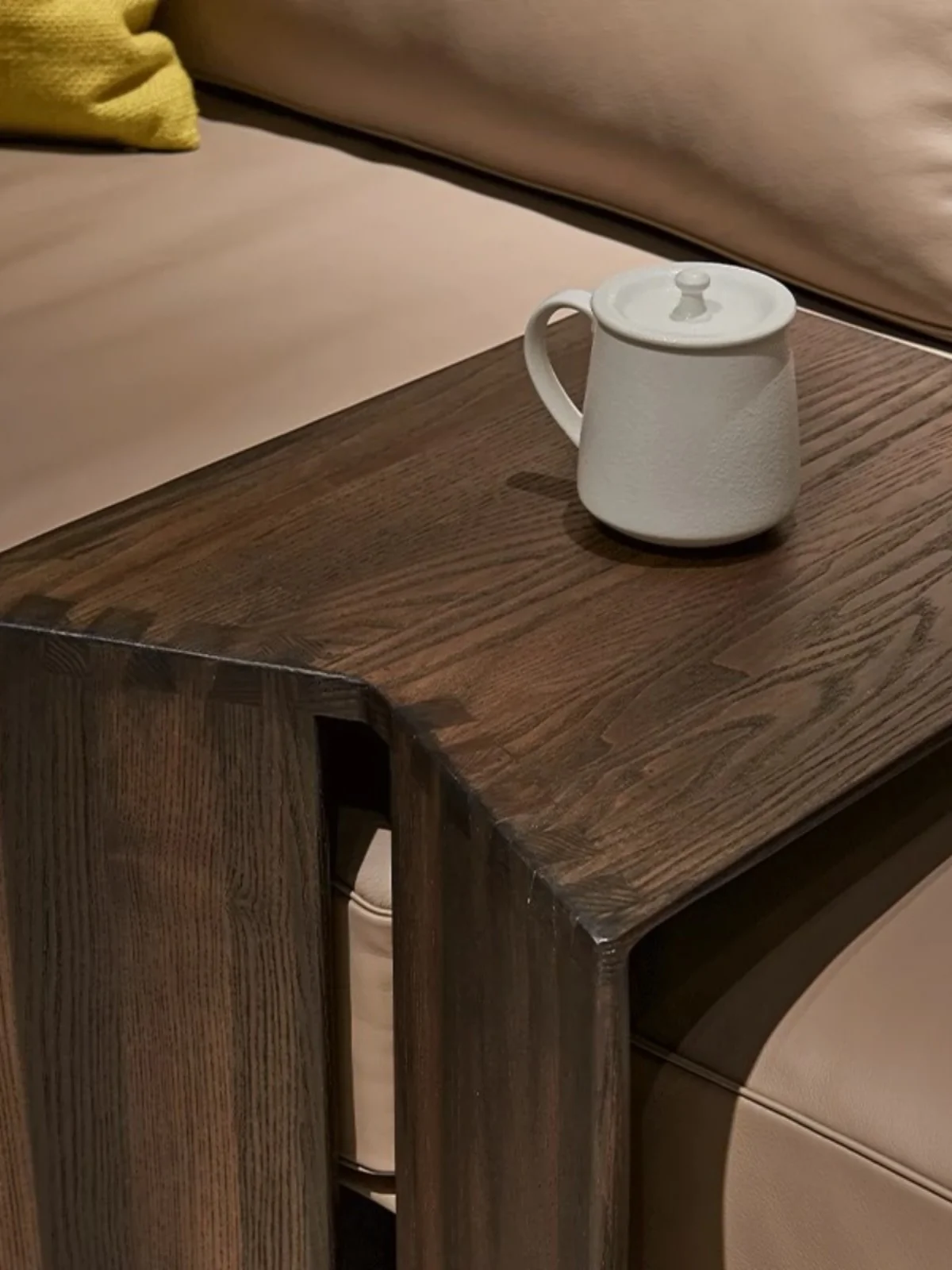 طاولة مربعة صغيرة من الخشب الصلب، زاوية أريكة، غرفة معيشة بسيطة وحديثة، شقة منزلية صغيرة