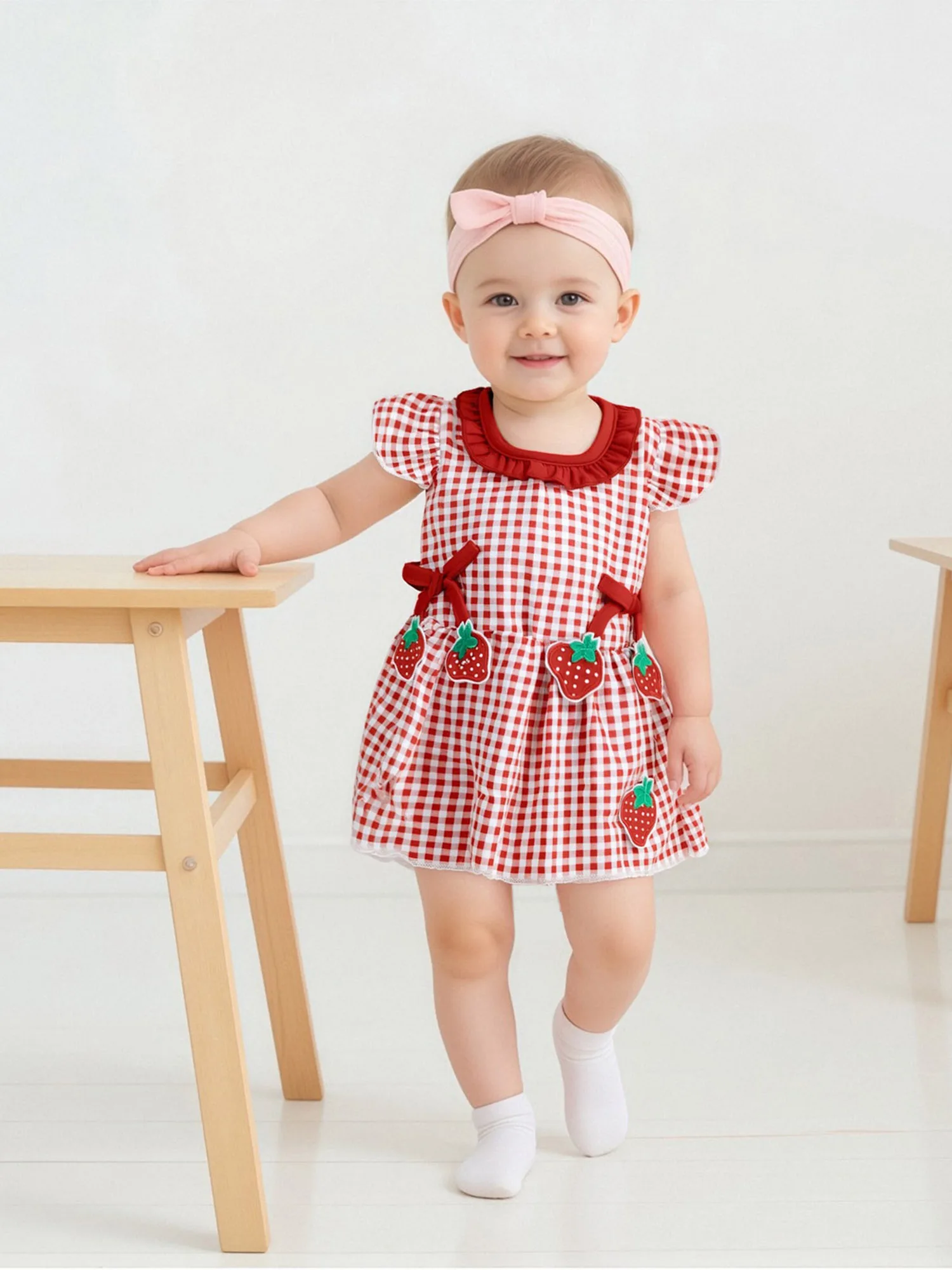 Abito da bambina con maniche a volant con stampa floreale e dettaglio fiocco per la festa di matrimonio estiva sulla spiaggia e il servizio fotografico di famiglia