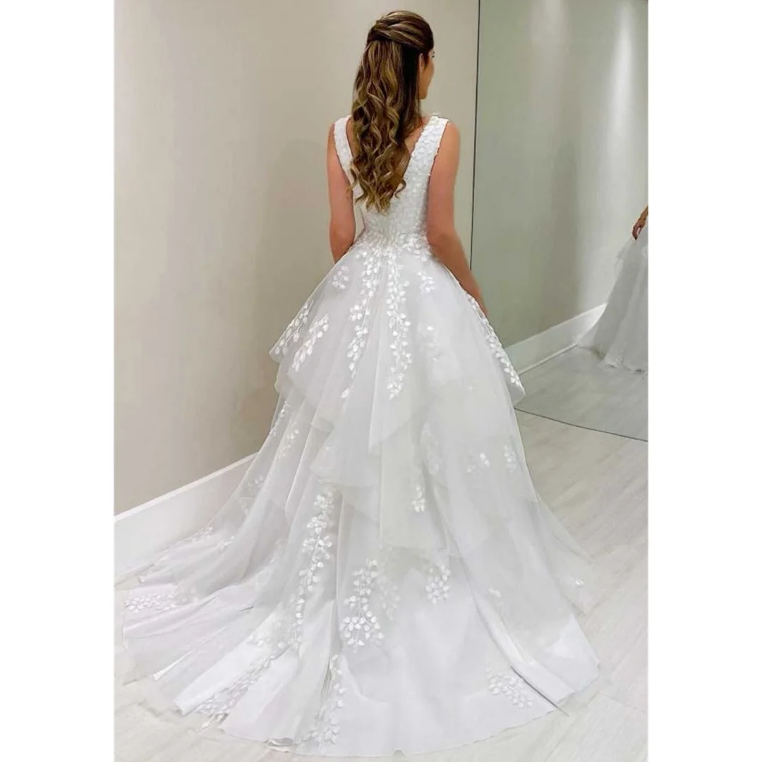 ชุดแต่งงานคอวีแขนกุด ดีไซน์หรูหรา ประดับด้วยลูกไม้ระบายเป็นชั้นๆ ชายกระโปรงไม่สมมาตร พร้อมชายกระโปรงยาวแบบคอร์ทเทรน เหมาะสำหรับงานแต่งงานหรืองานพรอม