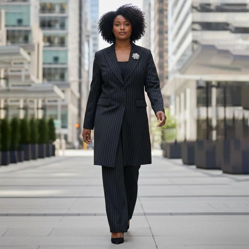 

Элегантный черный женский костюм-двойка в тонкую полоску: пиджак с острыми лацканами и брюки. Высококачественная женская одежда.