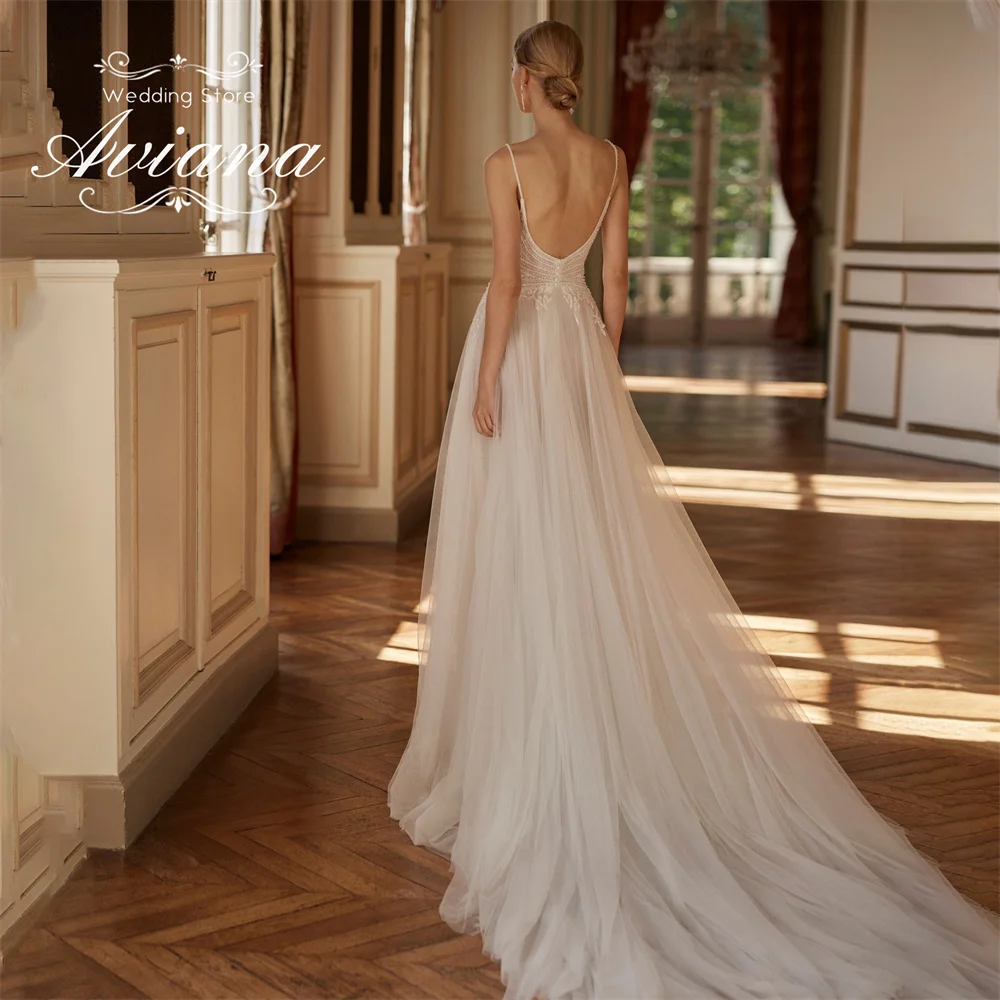 فستان زفاف مخصص من Aviana مزين بالدانتيل على شكل حرف a عميق على شكل حرف v وحزام سباغيتي سويب تراين ترتر بفتحة جانبية عالية من التل