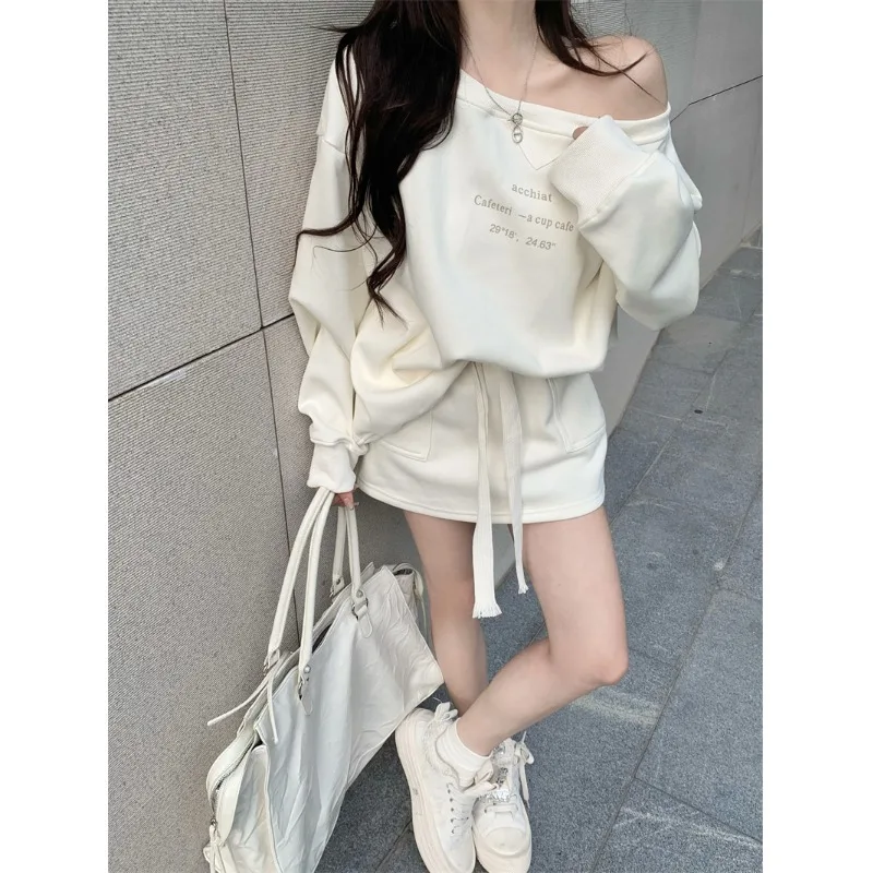 

Спортивный комплект из двух предметов: топ на одно плечо с принтом и длинными рукавами, осенняя юбка. Повседневный стиль для молодых женщин.