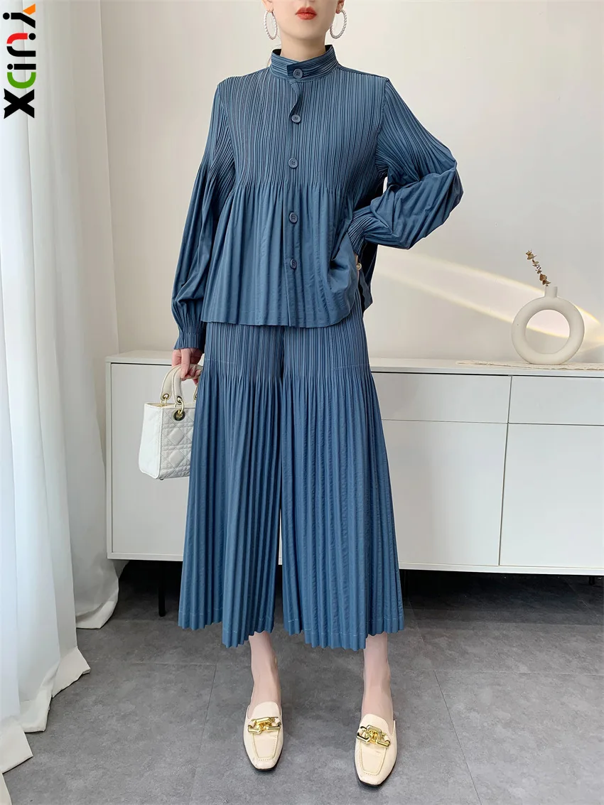 

Плиссированный топ с высоким воротником и рюшами цвета пыльно-голубого оттенка от Miyake + широкие брюки (продавются отдельно). Легкий женский повседневный комплект для отпуска в стиле бохо.