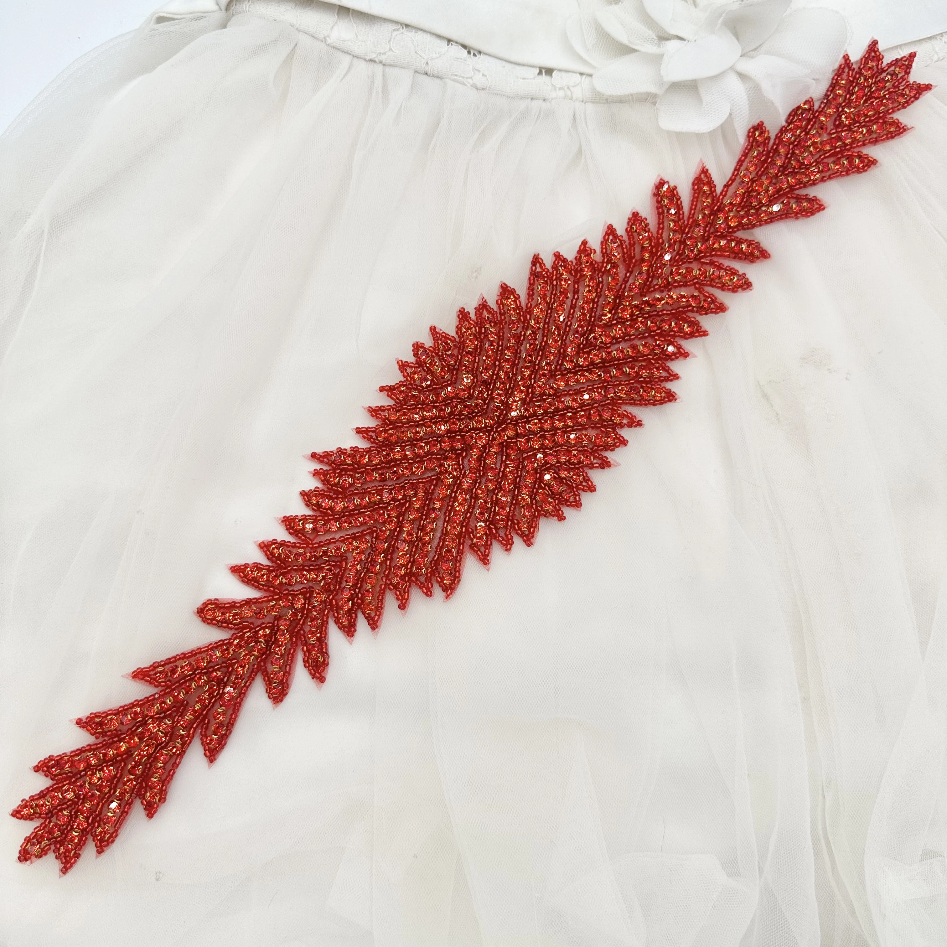 

Ярко-красные длинные лентообразные листья с обильной вышивкой бисером и аппликациями из пайеток используются как украшения для талии, плеч или боковой части груди, подходят для белых свадебных платьев.