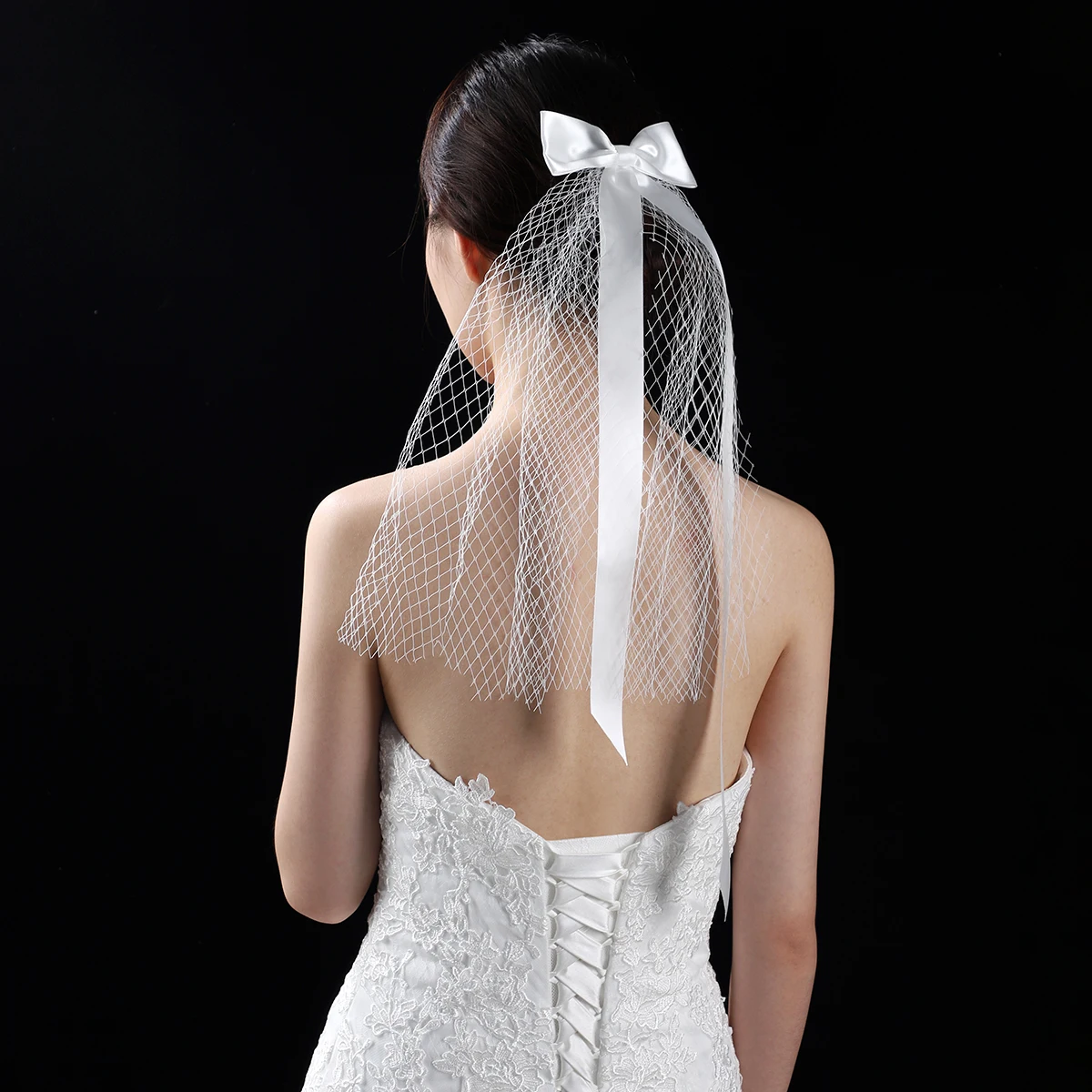 A white elegant bridal veil adorned with a simple bow, shoulder length veil suitable for women's weddings