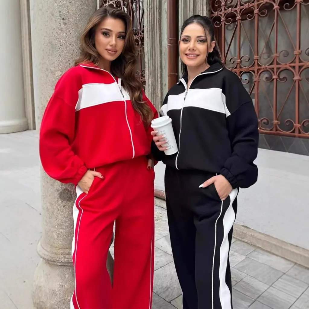 Damski zestaw w stylu casual streetwear: bluzka z wysokim kołnierzem i zamkiem błyskawicznym oraz proste spodnie w kontrastowe paski, dwuczęściowy komplet.