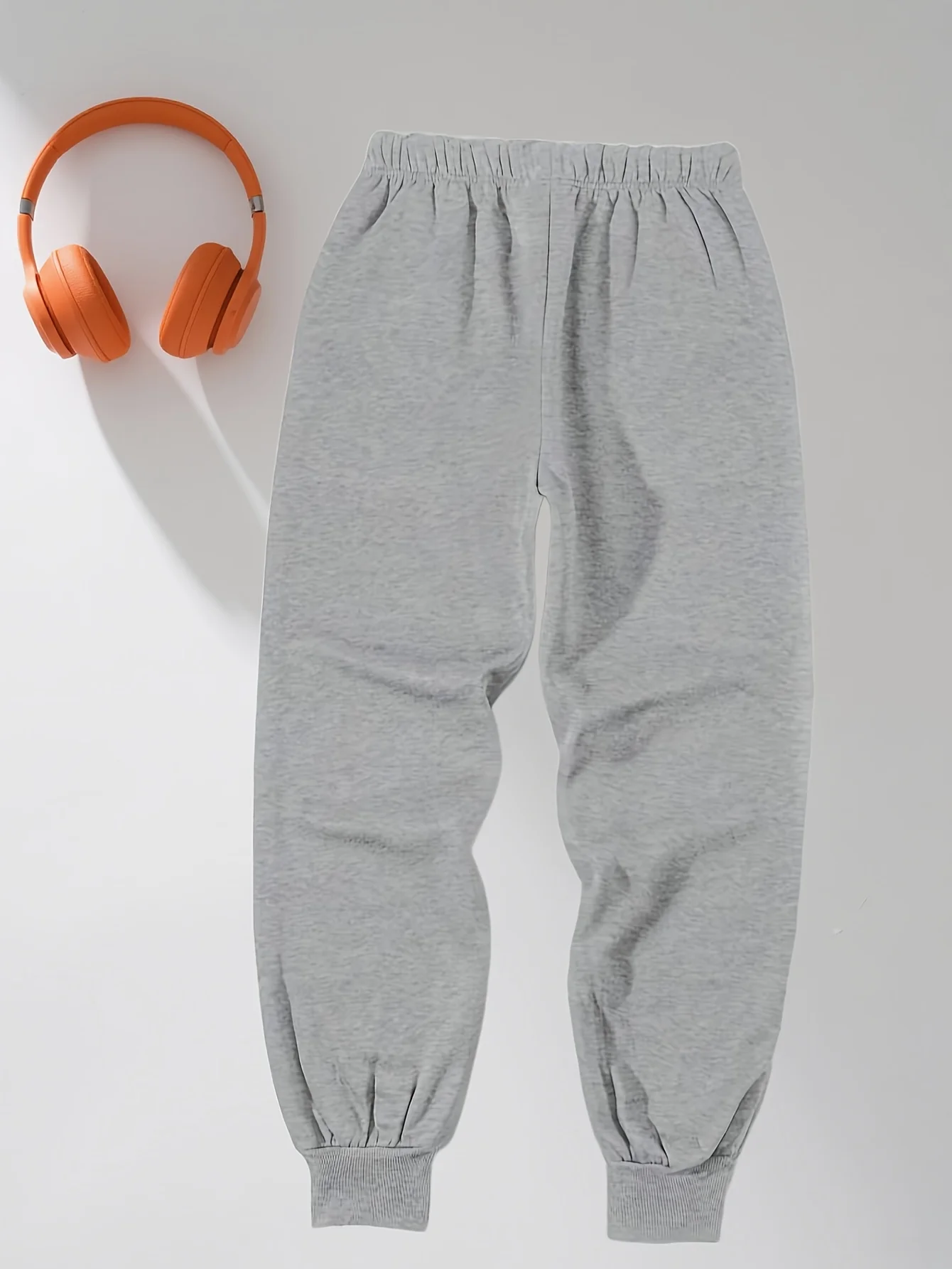 Calça de moletom casual masculina cinza folgada com punhos enrolados no tornozelo e cintura com cordão, adequada para todas as estações.