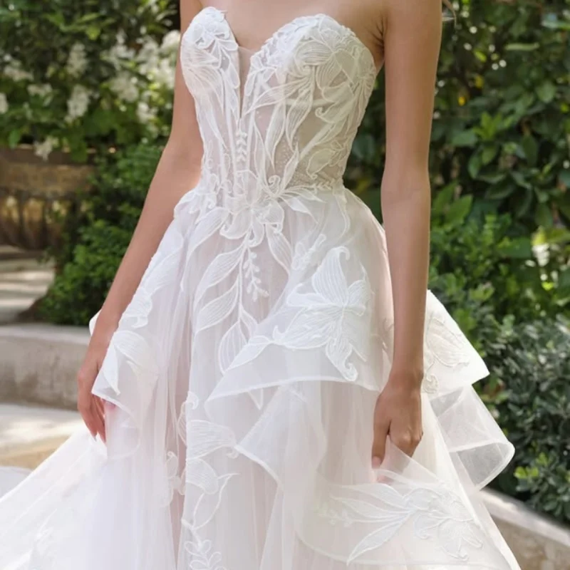 ชุดแต่งงานสีขาว ประดับด้วยลูกไม้ ปักลายดอกไม้ ชุดแต่งงานแบบมีชั้น ทำจากผ้าลูกไม้ ชุดแต่งงานสั่งทำพิเศษ