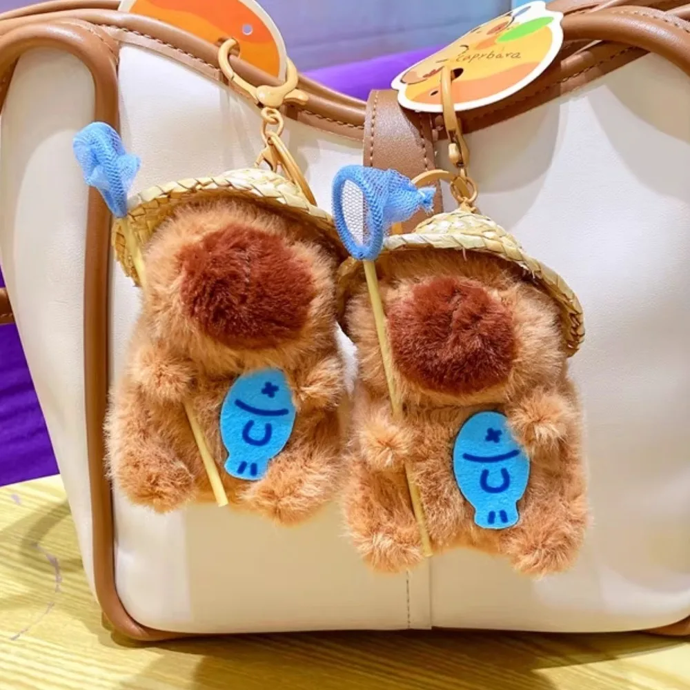 พวงกุญแจคาปิบาราถือตาข่ายจับปลา ตุ๊กตาคาปิบาราใส่กระเป๋า  ทำจากผ้าฝ้าย PP  รูปการ์ตูนสัตว์ตลก สำหรับเด็ก