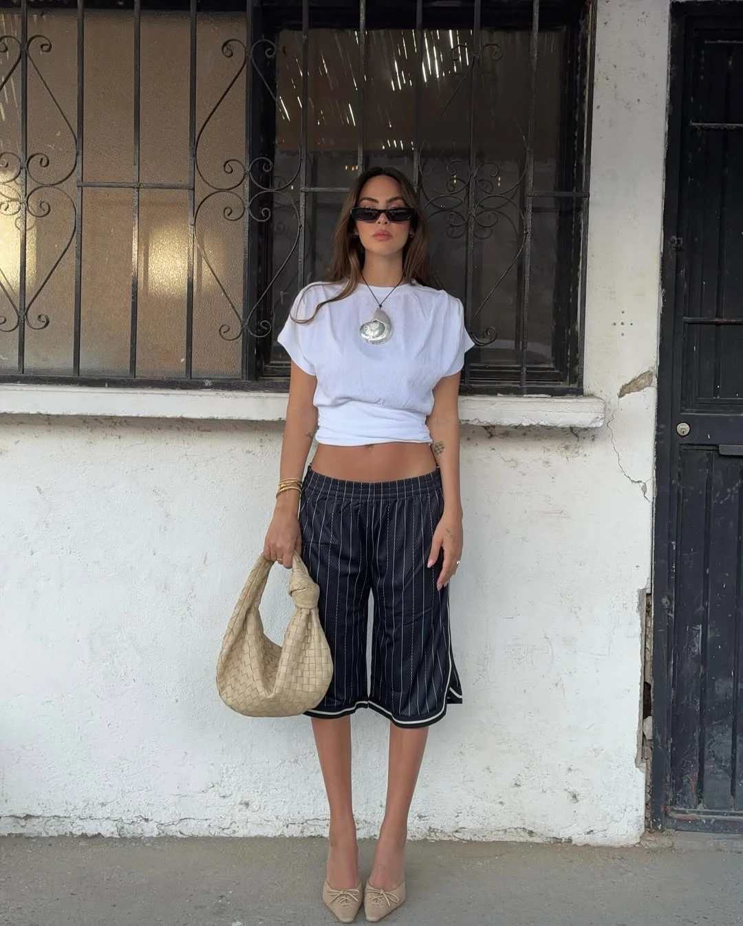 

Белая приталенная футболка с круглым вырезом и джинсами из бамбукового хлопка простого и трехмерного кроя.