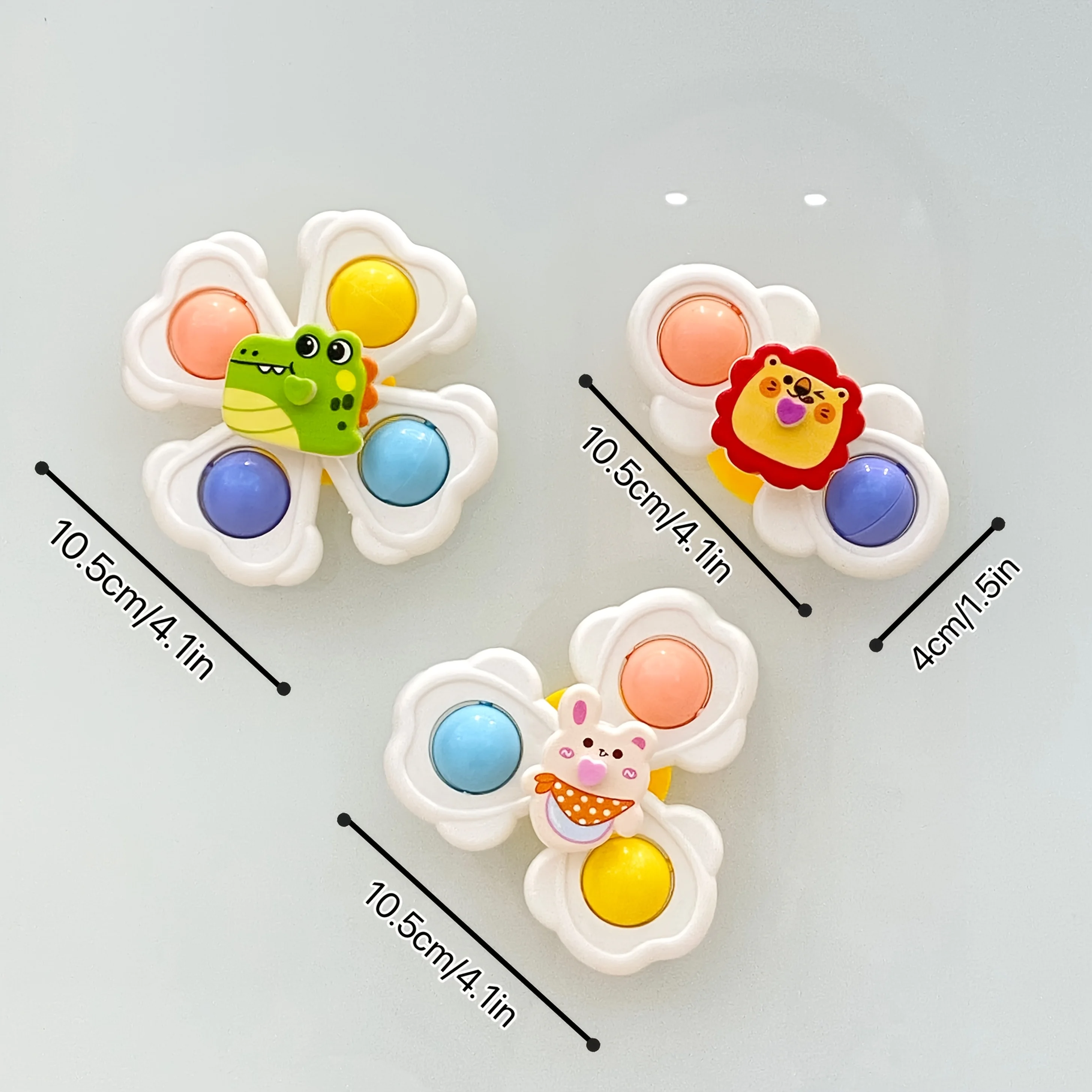 Un set di tre trottole con ventosa per animali dei cartoni animati per neonati progettate per migliorare la coordinazione occhio-mano durante le prime prime