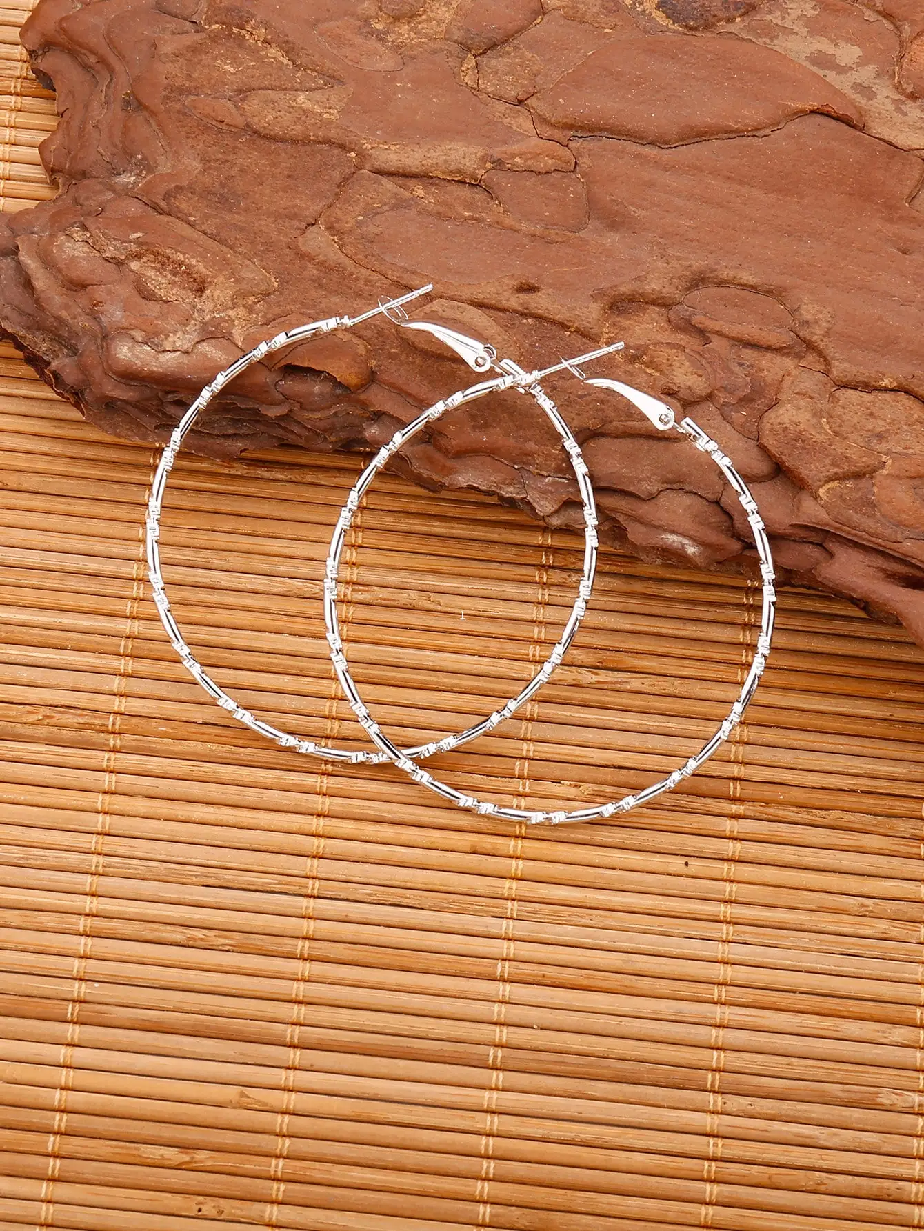 Pendientes de aro texturizados en tono plateado con cierre seguro tipo palanca