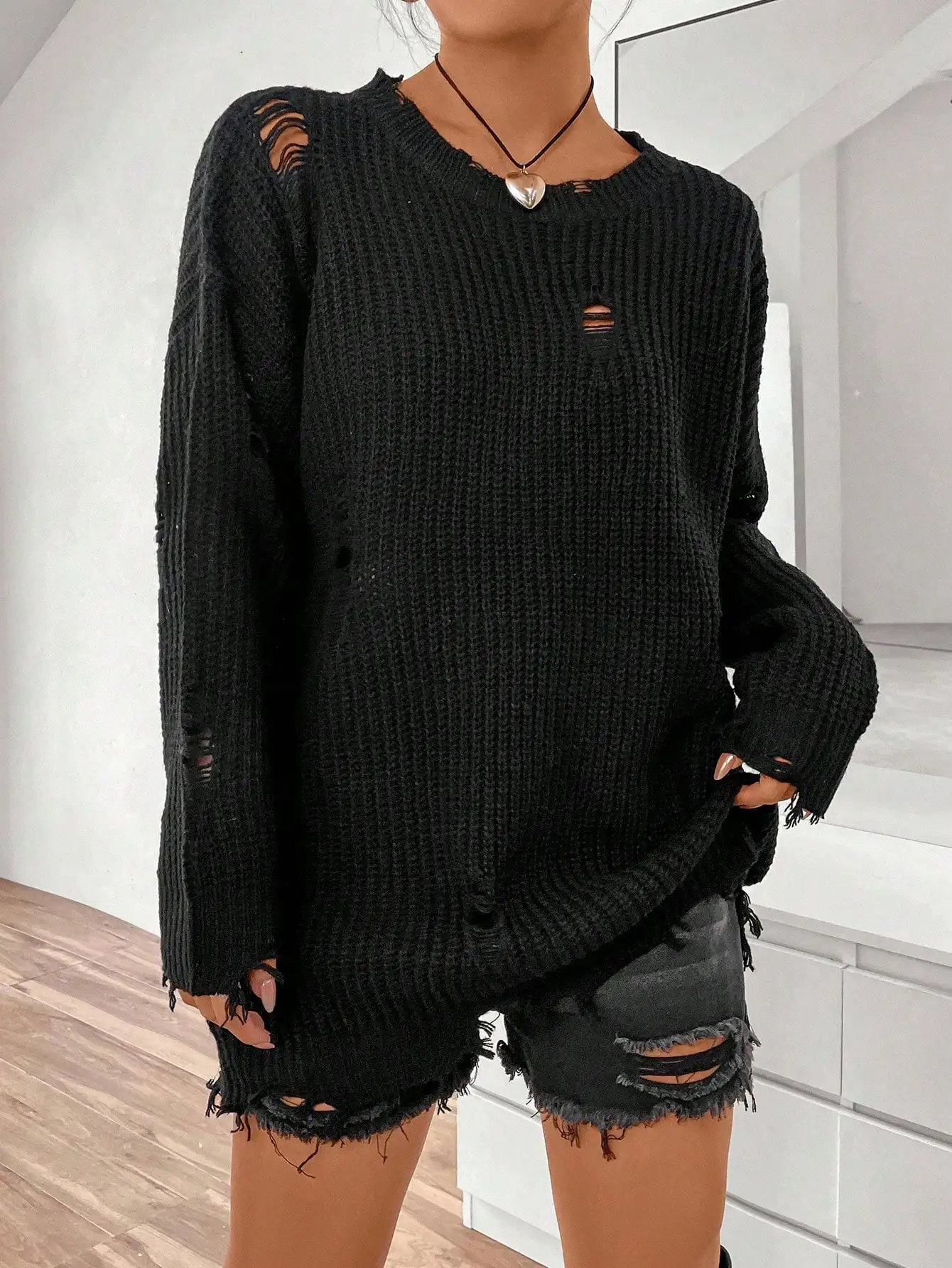 Damski sweter z dzianiny o luźnym kroju, z długim rękawem i obniżonymi ramionami, z efektem zniszczenia.