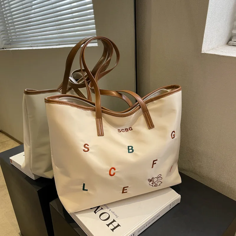 The new 2023 han edition letter hitting scene embroidery tottenham nylon fabric bag leisure mummy large capacity one shoulde