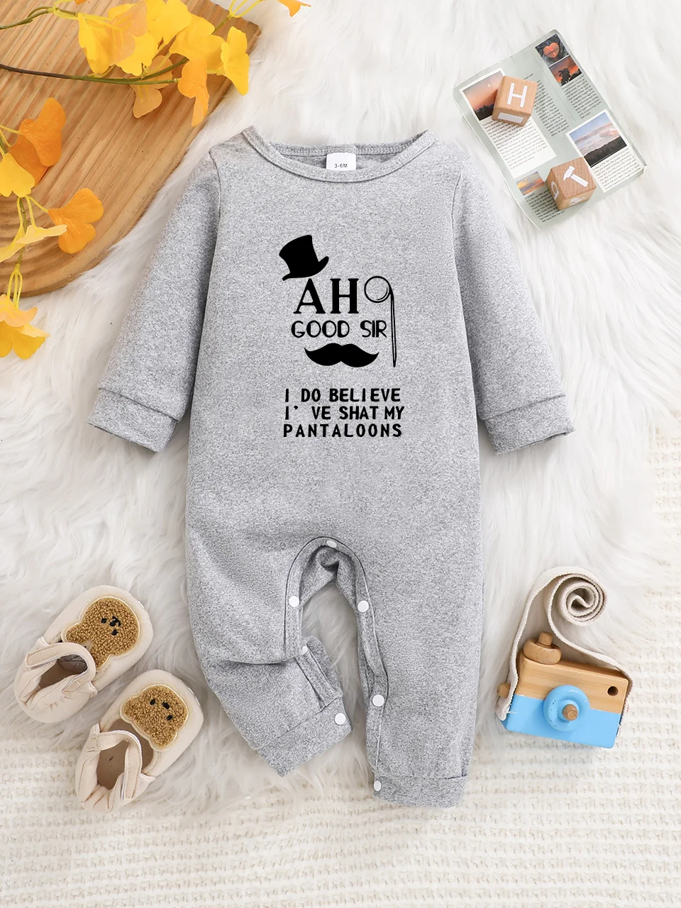 A baby long-sleeved onesie with interesting letter prints. It features a buttoned design for easy putting on and taking off, and