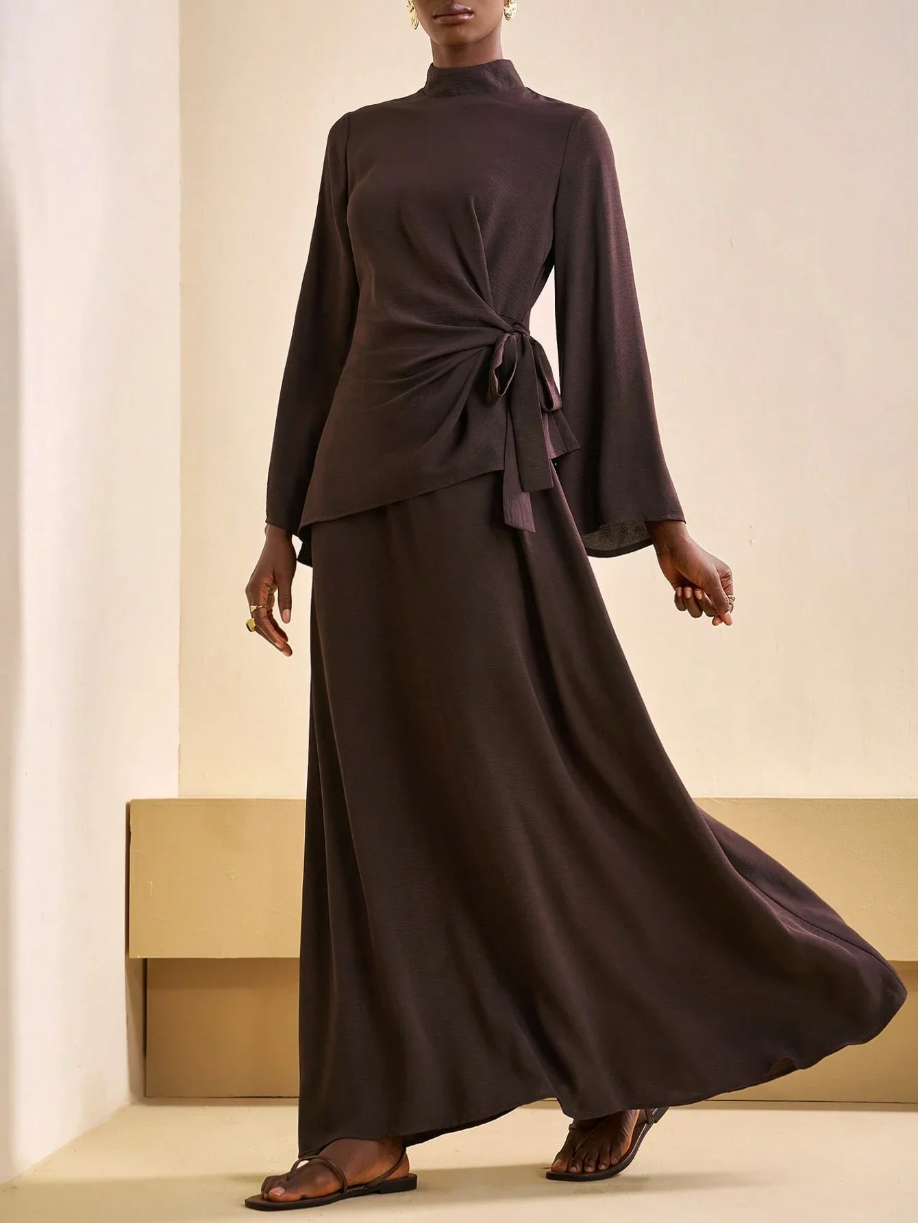 

Brown Modest Two-Piece Set: High-Neck Wrap Top With Bell Sleeves, Tie-Waist Draped Asymmetry And Flowy A-Line Maxi Skirt