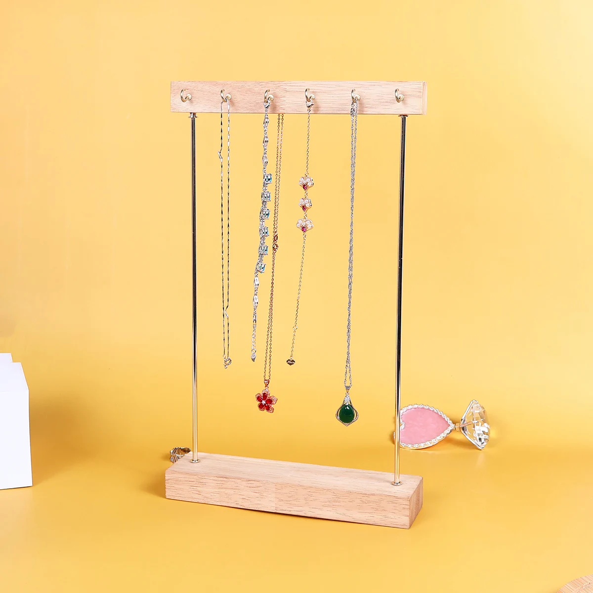 

Простая деревянная/металлическая витрина для ювелирных изделий с несколькими крючками, которая поможет вам аккуратно хранить ожерелья и серьги; он может иметь