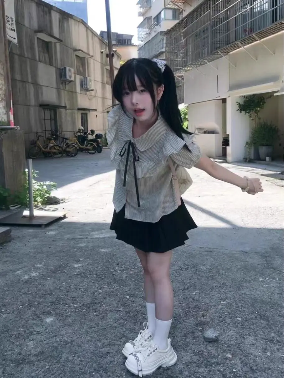 Het zomernieuwe gestreepte shirt met korte mouwen en korte rok uit 2025, een lief meisje