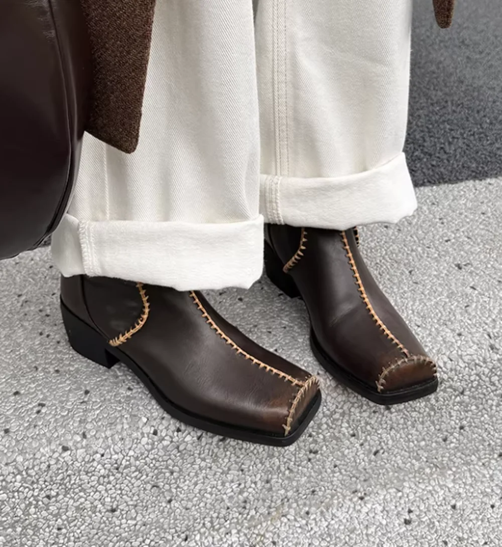 

Минималистичные кожаные ботильоны в западном стиле с квадратным носком, контрастной белой строчкой и массивным каблуком-блоком, в стиле Cool Glam