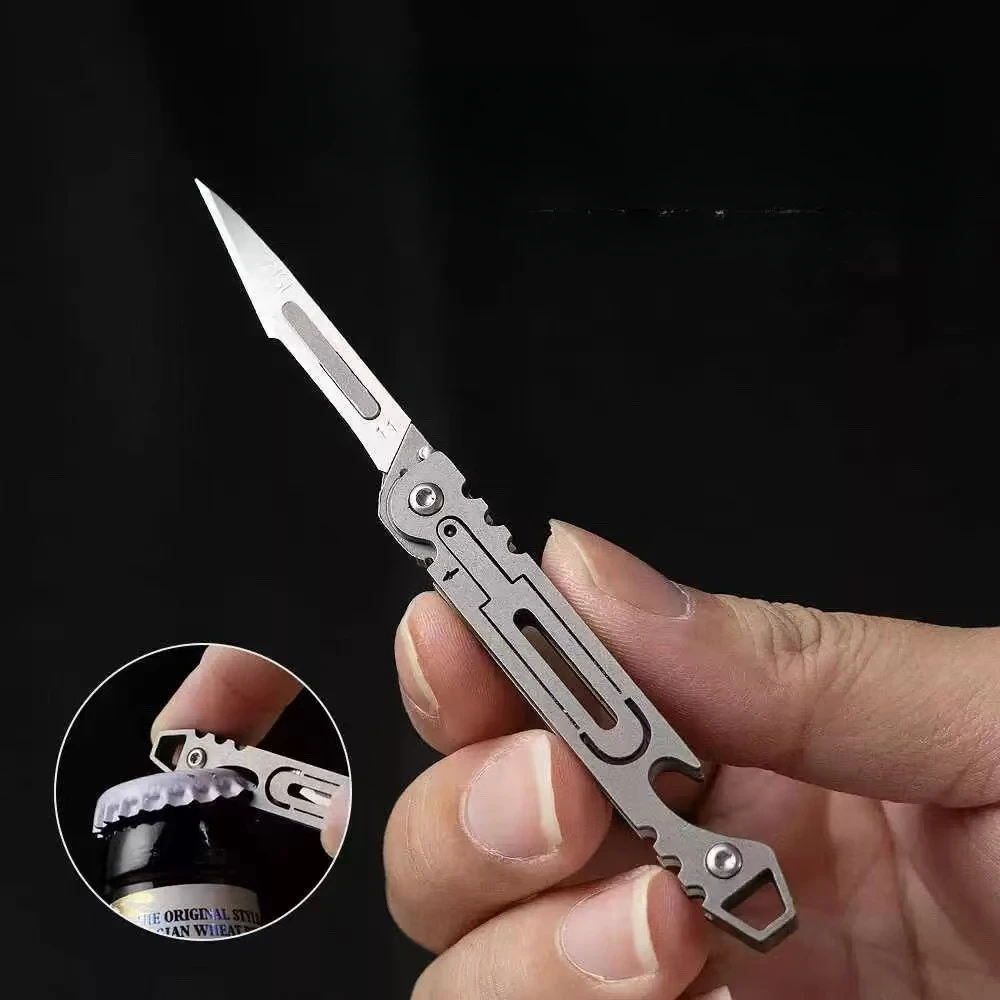 ใหม่ Mini Titanium Alloy มีดพับกลางแจ้ง Camping แบบพกพา EDC มีดมาพร้อมกับใบมีดฟรี 10 ชิ้น