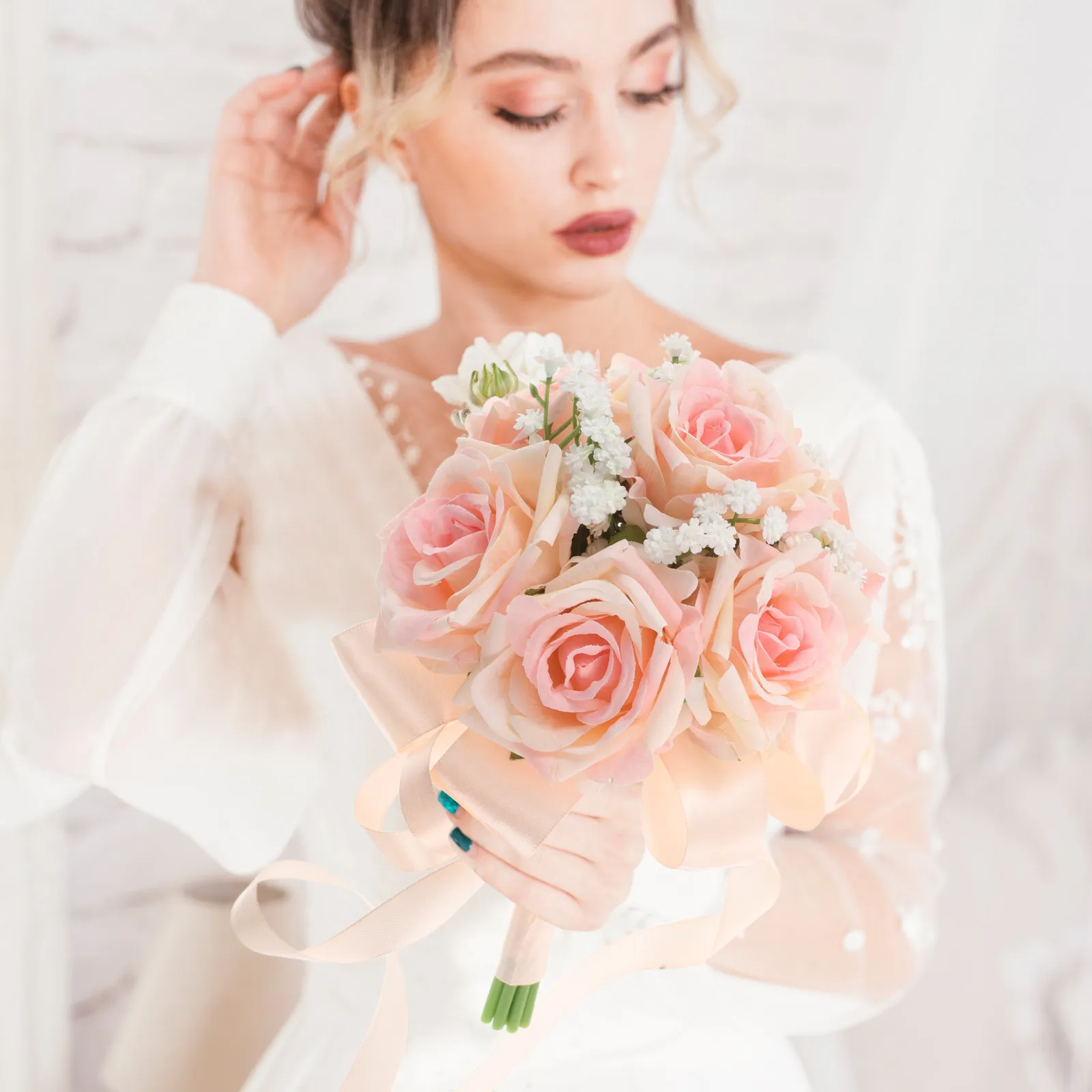 ロマンチックなピンクのウェディングブーケ。人工の花を使用し、新婦や介添人に手渡すのに適したサイズ。屋外でのウェディングフォト撮影の装飾にも。