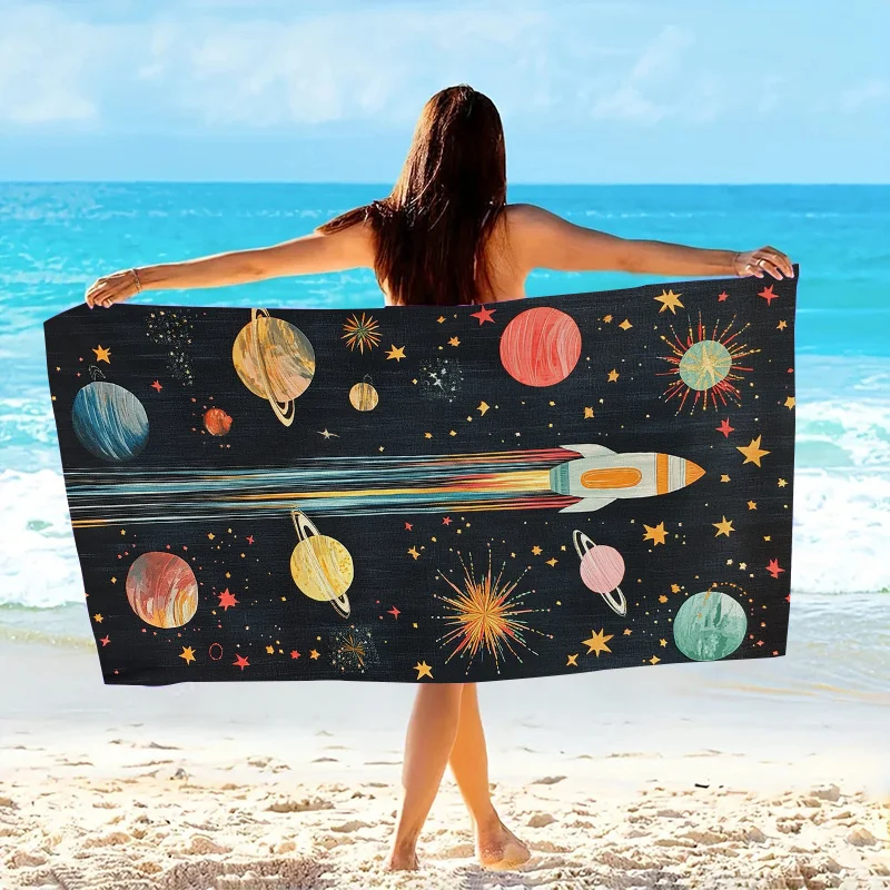 この単品スペースロケットビーチタオルは、明るい色の惑星柄が特徴で、柔らかいマイクロファイバー生地で作られています。
