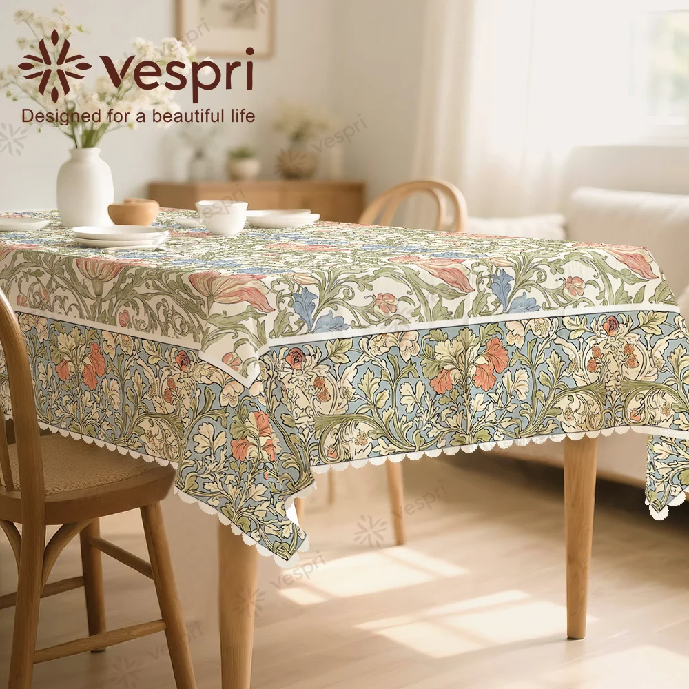 Vespri Spring Tablecloth, with green and blue decorations, featuring green leaves and flowers, circular shape.