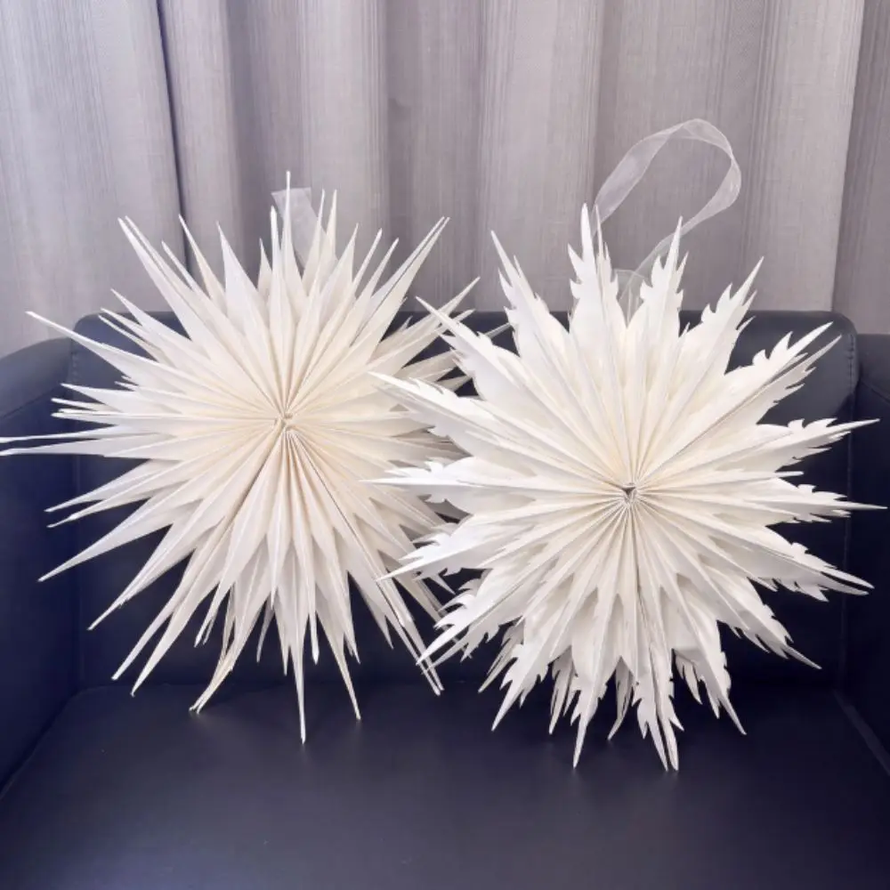 白い紙で作られた雪の結晶の軽量オーナメント。切り抜きデザインで、立体的な視覚効果を生み出すクリスマス飾り。