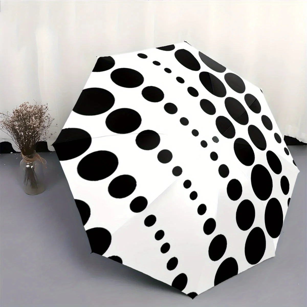 

This Is a Portable Automatic Folding Umbrella Featuring Black Polka Dots on a White Backdrop. It'S a Convenient Accessory for