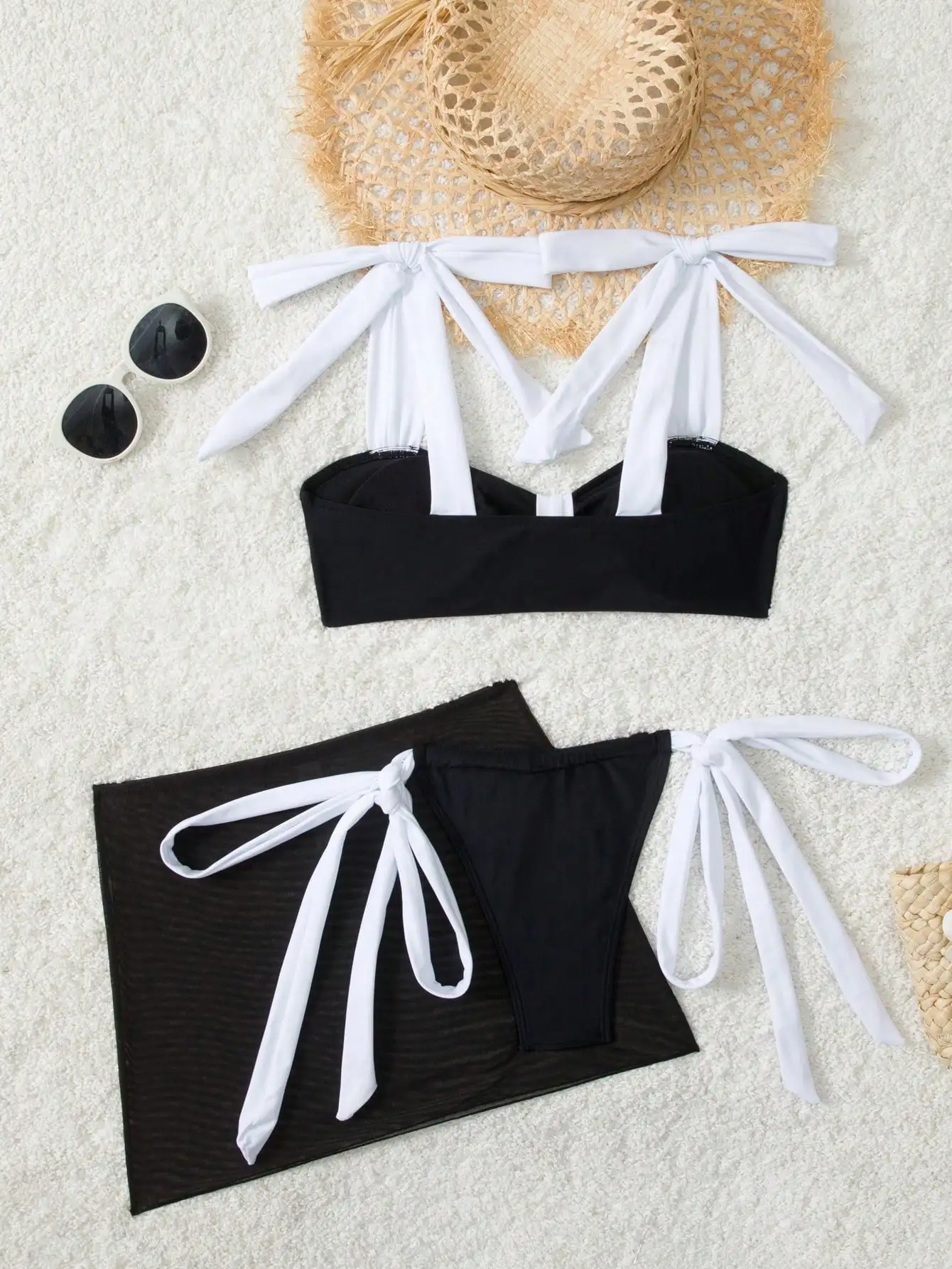 

Черно-белый комплект из трех предметов: сетчатая накидка на завязках и купальник для летнего пляжного отдыха