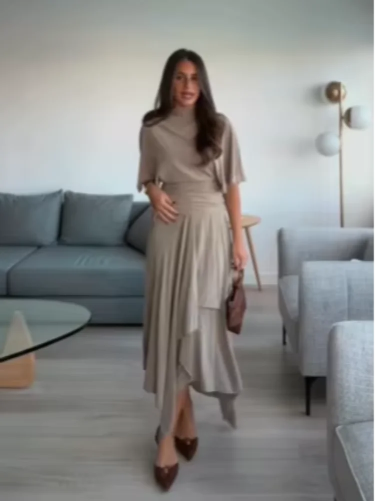 

Стильный повседневный комплект: топ с высоким воротом и рукавами «летучая мышь» и плиссированная юбка миди. Весенний повседневный наряд для женщин 2026.