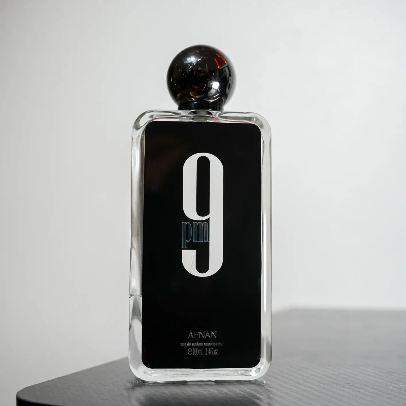 AFNAN 9 PM EAU DE PARFUM | La bergamota y la lavanda abren el capítulo nocturno, la picante intensidad de la pimienta negra, la cálida base de sándalo, pachuli y vainilla, interpretan un estilo masculino maduro para la noche.