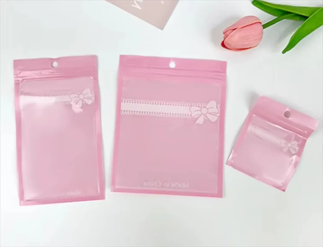 

100PCS Pink Plastic Bow Ziplock Bags Clear Resealable Jewelry Pouches for DIYCosmetics Nails Beauty Puffs Gift Packaging Storage