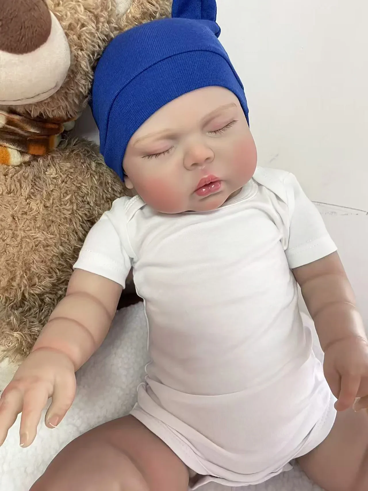 bambola-reborn-da-24-pollici-pickle-con-cappello-blu-scuro-e-tuta-bianca-a-maniche-corte-pittura-a-strati-multipli-capelli-applicati-a-mano