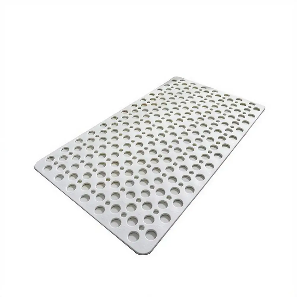 Blue bathroom mat with suction cups and drainage holes on a wet tiled floor.