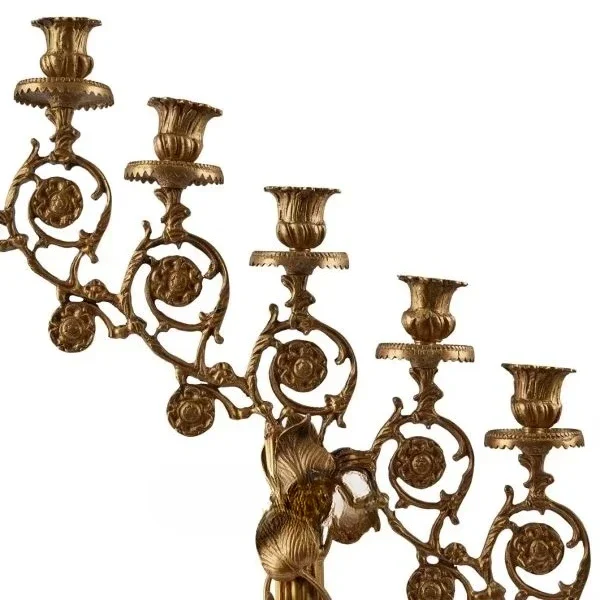 Antique brass candlesticks with ornate art prints and multiple curved arms for elegant vintage home decor