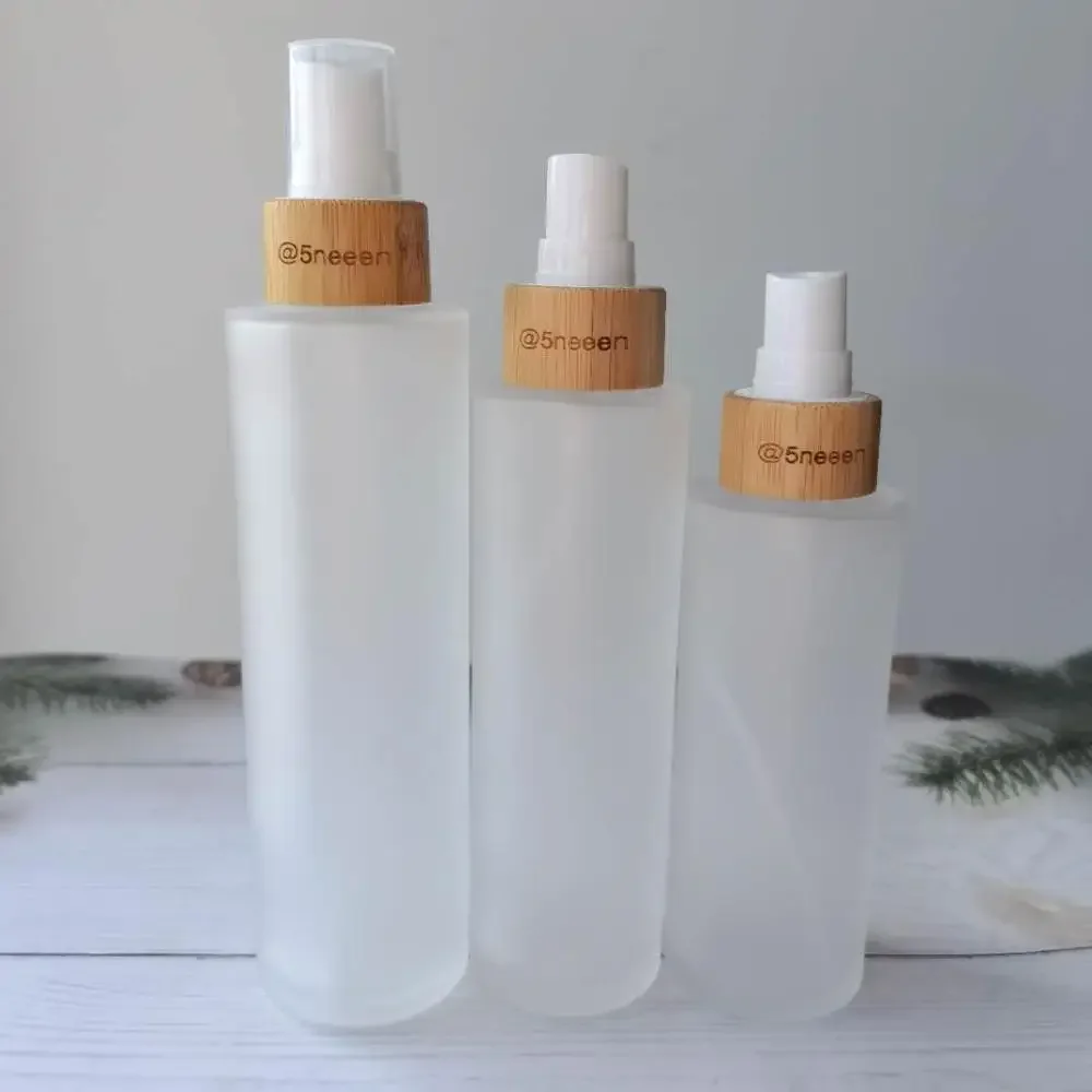 

Wholesale clear Frosted Glass Bottles for Cosmetics Bottles with Bamboo Lid Covered spray bottle mist lotion bottles with pump