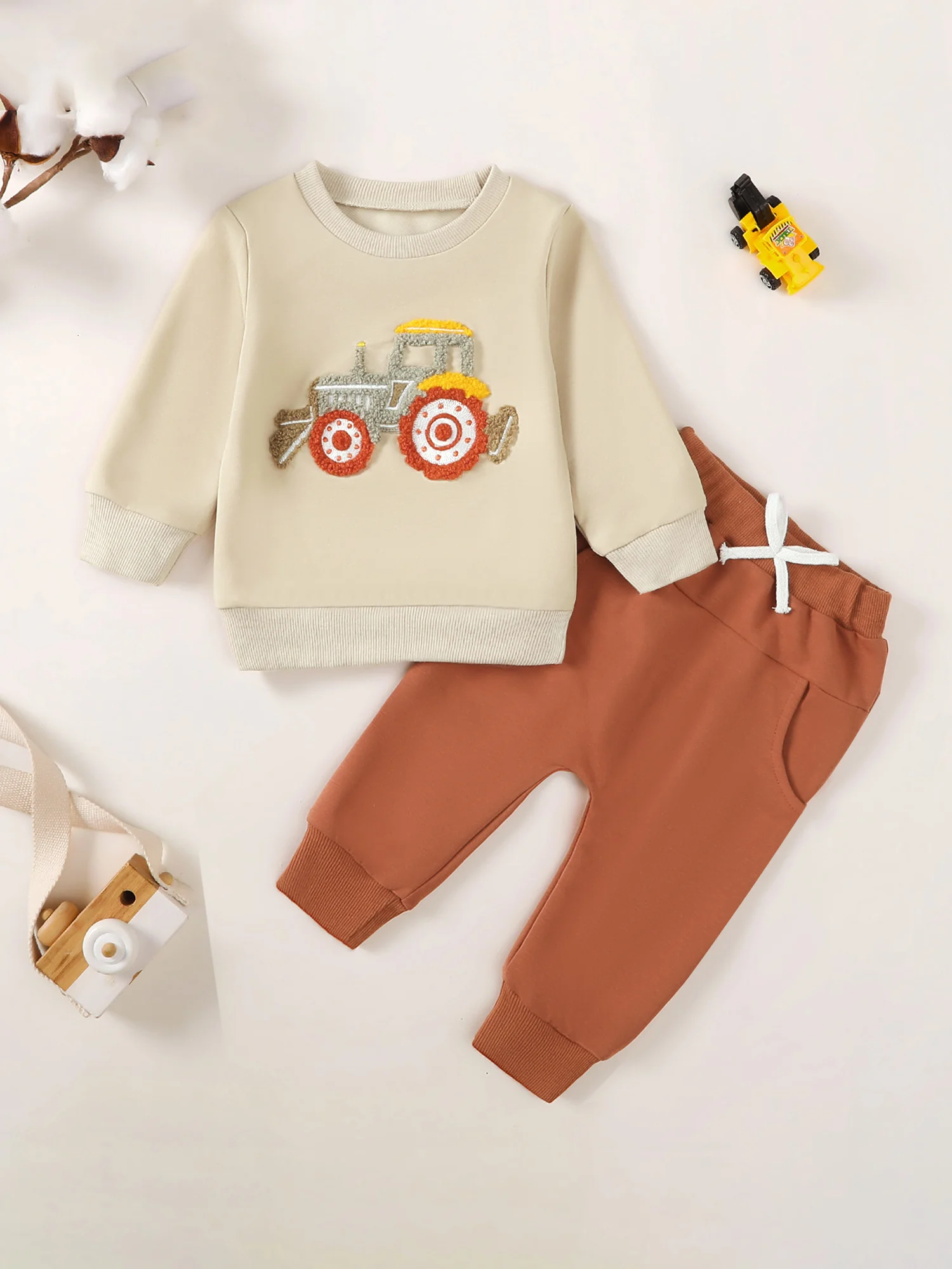 

Очаровательный наряд для маленьких мальчиков. Стильная толстовка с аппликацией для трактора и однотонные брюки в тон — осенний ансамбль из двух предметов.