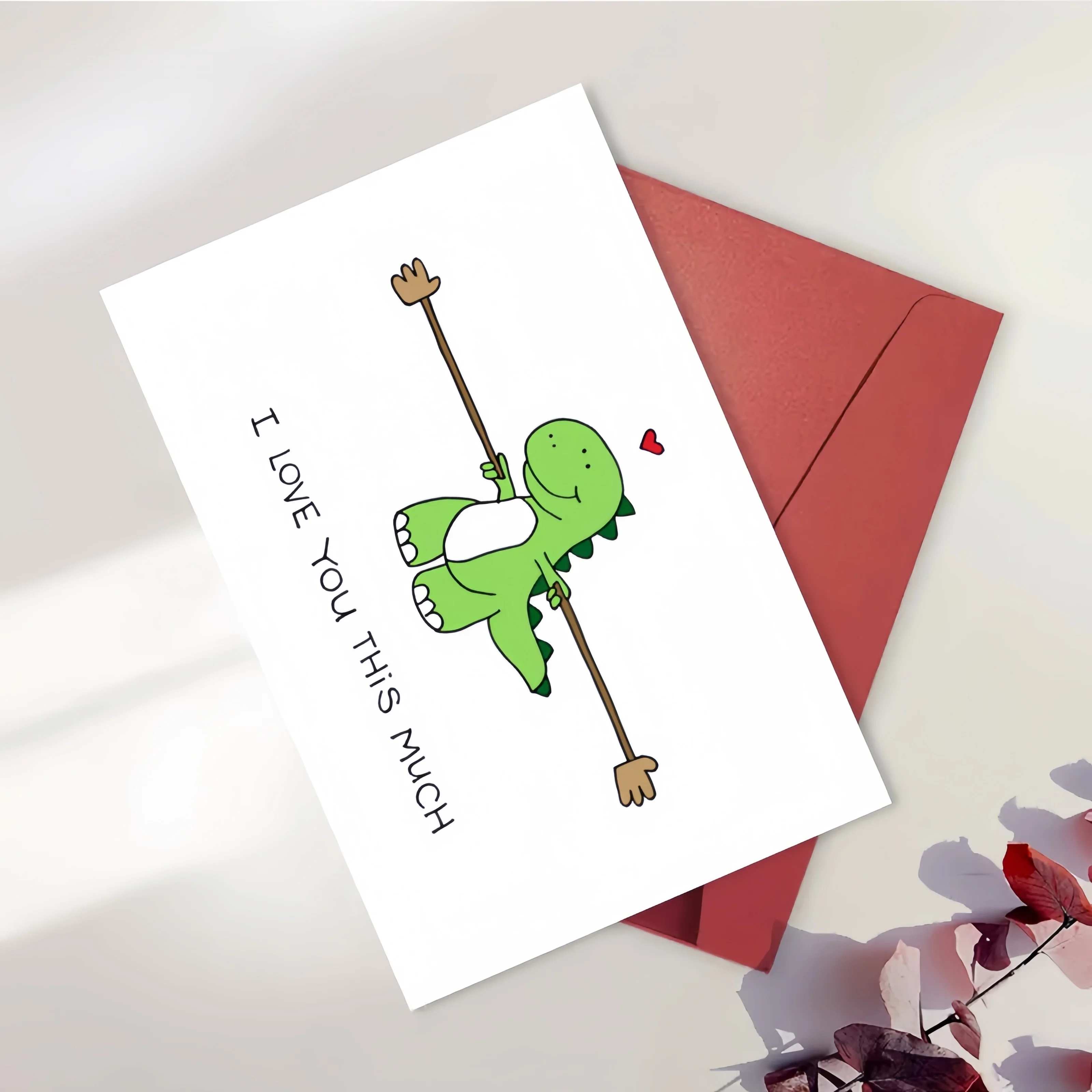 بطاقة تهنئة تحت عنوان الديناصور مع حرف حب مغلف "أنا أحبك كثيرًا"، مناسبة للمناسبات الخاصة مثل أعياد الميلاد