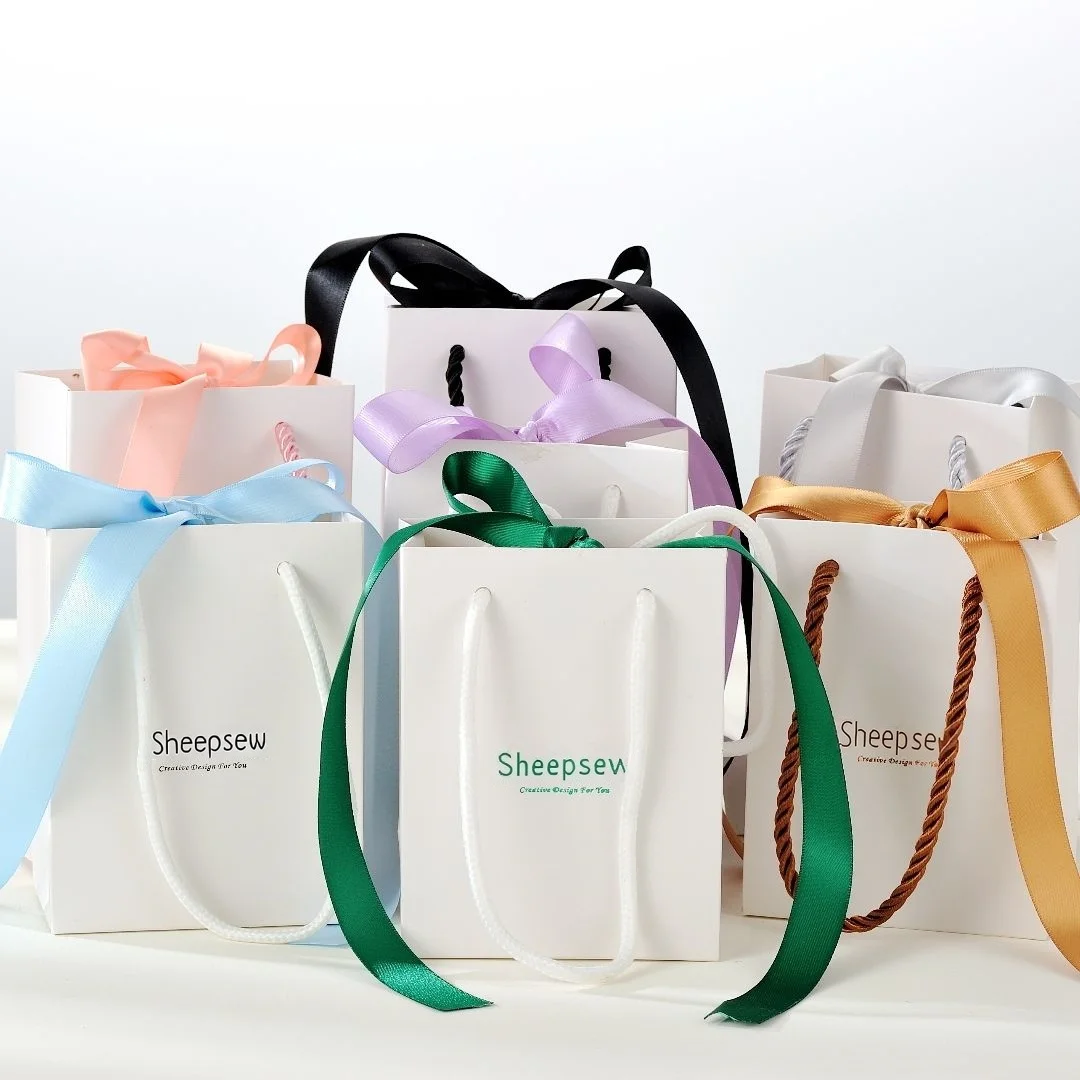 

Пользовательский логотип, многоразовые белые, черные сумки для покупок из крафт-бумаги, портативные дорожные сумки для упаковки свадебных подарков с лентой-бантом