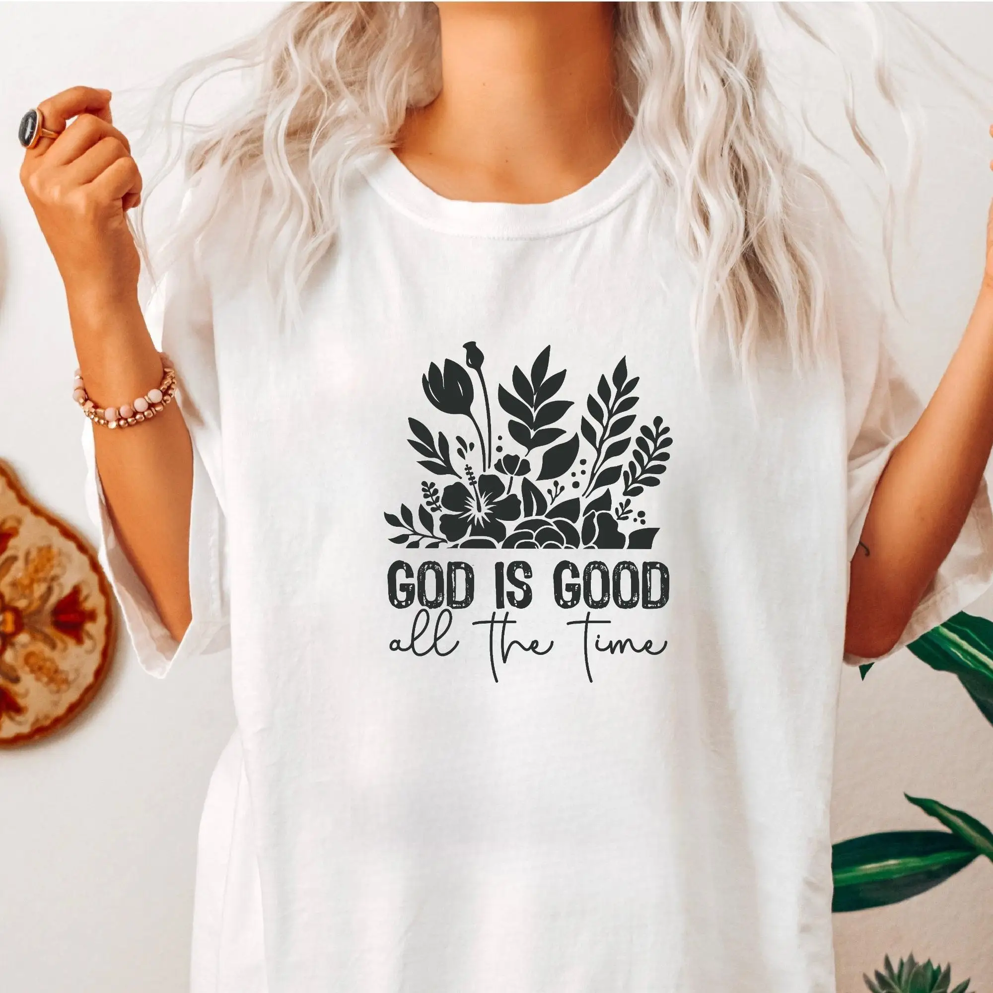 

T - shirt featuring a flower bouquet graphic paired with the inspirational text “GOD IS GOOD all the time