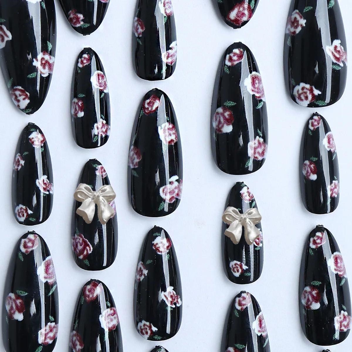 24枚入り 光沢のある黒アーモンド型つけ爪 ピンクの花柄プリント付き プレスオンネイル オーロラリボン飾り付き スイートでクールなフェイクネイルパッチ